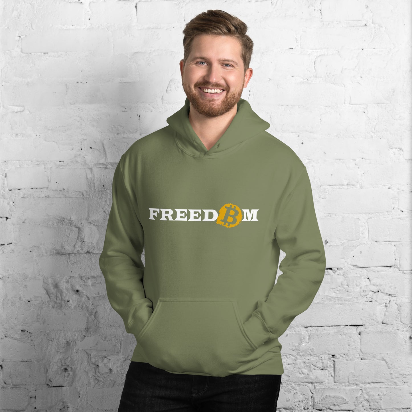 Male model wearing a military green heavy blend hoodie with the word ‘Freedom’ written on it in white letters. The letter ‘o’ is replaced with the orange bitcoin logo.